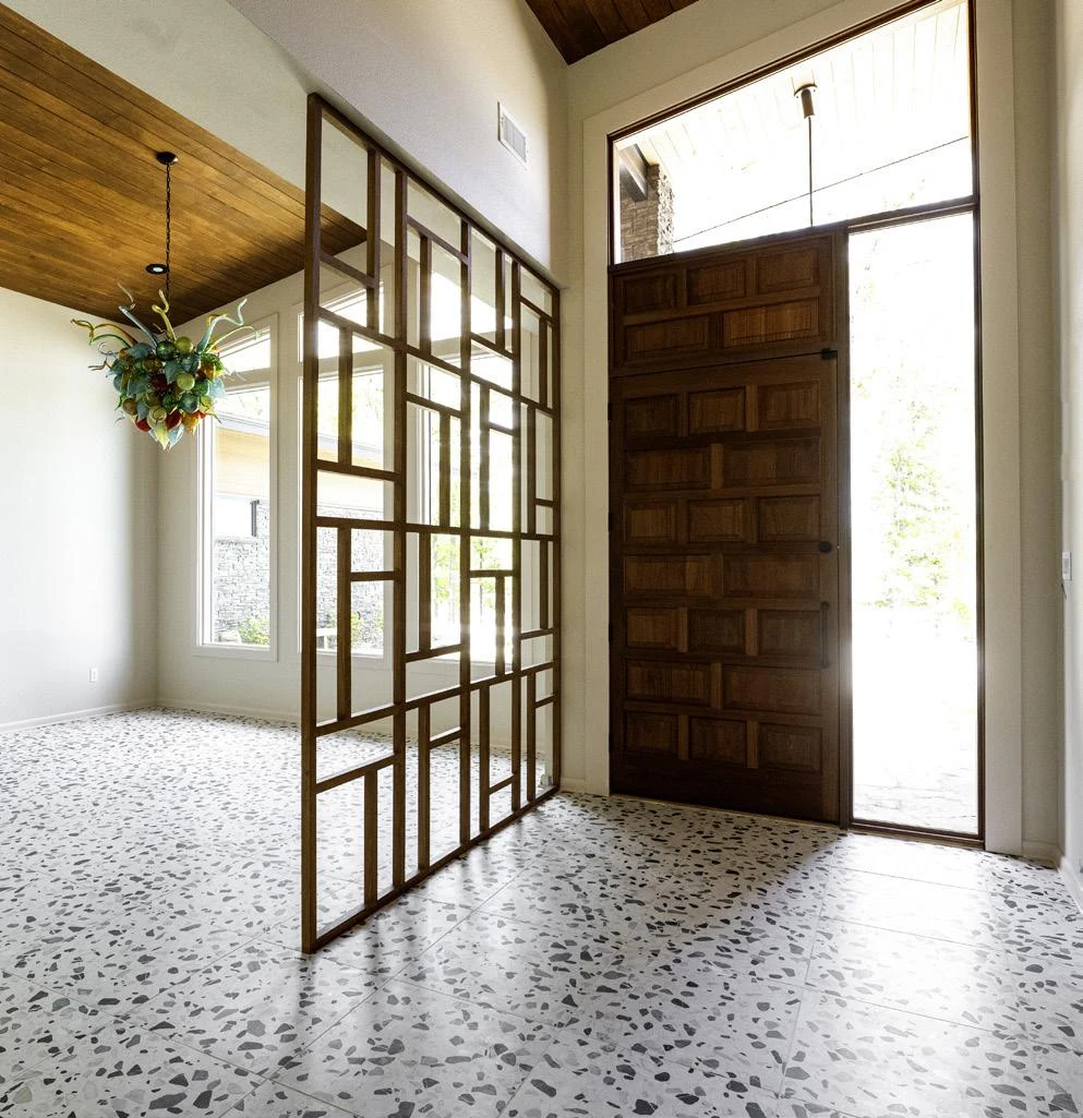 Terrazzo floors and geometric woodwork carry the design through the home.