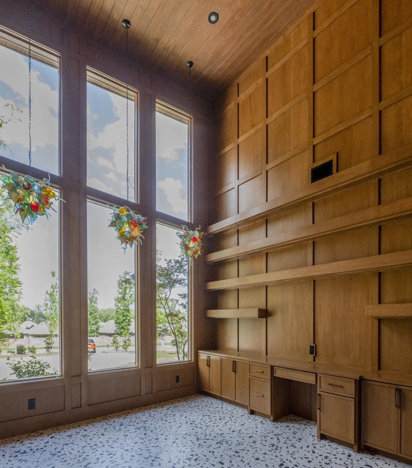 Double-height study with wood-paneled walls and tall windows